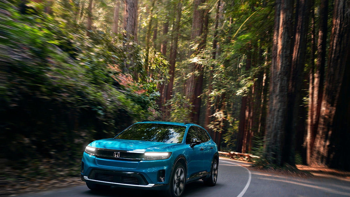 2025 Honda Prologue Elite electric SUV driving on a winding forest road